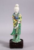 A CHINESE FAMILLE VERTE / BLANC DE CHINE PORCELAIN FIGURE OF GUANYIN & STAND, stood holding a ruyi