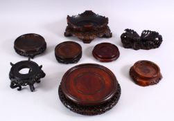 A MIXED LOT OF EIGHT LARGE CHINESE CARVED HARDWOOD STANDS, various styles and sizes. 18cm down to