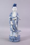A CHINESE 19TH / 20TH CENTURY BLUE & WHITE PORCELAIN FIGURE OF GUANYIN, stood holding a vessel, upon