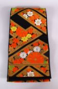 A FINE QUALITY JAPANESE EMBROIDERED SILK FUKURO OBI TIE, with a black ground and floral and gilt