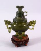 A CHINESE CARVED JADE LIDDED POT & COVER, with twin dragon head handles, on three feet, with a
