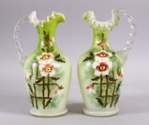 A 19TH CENTURY PAIR OF OPALINE GLASS MOULDED JUGS, with a moulded rim and floral painted decor, 25cm