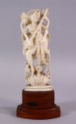 A 19TH CENTURY INDIAN CARVED IVORY FIGURE OF A MULTI ARM DEITY, playing a musical instrument, on a