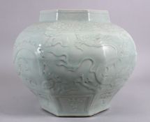 A LARGE CHINESE MING STYLE CELADON GLAZED OCTACONAL JAR, carved with dragons amongst waves, 29cm x