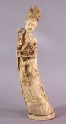 A LARGE 19TH CENTURY CHINESE CARVED IVORY FIGURE OF GUANYIN, stood holding a display of flora, the