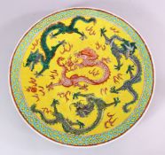 A 19TH CENTURY CHINESE FAMILLE JAUNE PORCELAIN DRAGON CHARGER, with central decoration of four