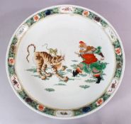 A LARGE 19TH CENTURY CHINESE KANGXI STYLE FAMILLE VERTE PORCELAIN CHARGER, depicting a warrior and