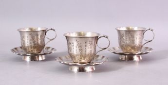 A SET OF THREE 19TH CENTURY CHINESE SILVER CUP & SAUCERS, each carved with a display of flora and