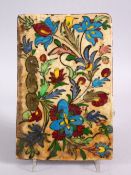A 19TH CENTURY OR EARLIER ISLAMIC QAJAR POTTERY TILE, decorated with floral spray, 22cm x 15cm.