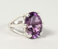 A SILVER OVAL CUT AMETHYST STONE RING.