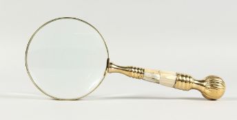 A MAGNIFYING GLASS WITH MOTHER-OF-PEARL AND GILT HANDLE.
