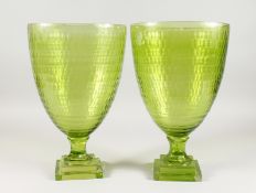 A PAIR OF LARGE GREEN TINTED PEDESTAL VASES on square bases. 14.5ins high.