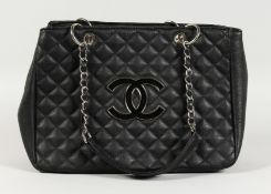 A CHANEL SOFT BLACK PADDED BAG with chrome and leather handles. 15ins wide.
