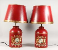 A LARGE PAIR OF RED TOLEWARE LAMPS AND SHADES.
