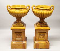 A GOOD LARGE PAIR OF LATE 19TH CENTURY TREACLE GLAZED POTTERY TWIN-HANDLED URNS of classical