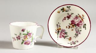 AN 18TH CENTURY MENNECY CUP AND SAUCER painted with flowers.