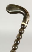 A 19TH CENTURY BOBBIN TURNED WALKING STICK with RHINO HANDLE. 35ins long.