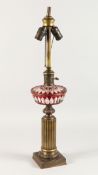 A GOOD RUBY GLASS LAMP, converted to electricity, on a column and a square base. 24ins high.