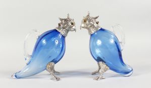 A PAIR OF NOVELTY BLUE GLASS CLARET JUGS, modelled as parrots, with plated mounts. 6.5ins high.