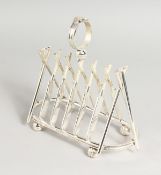 A SILVER PLATED CRICKET TOAST RACK, ten bats, stumps and balls.