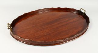 AN EDWARDIAN MAHOGANY OVAL TWIN-HANDLED TRAY. 28ins wide.