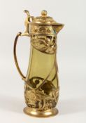 AN ART NOUVEAU LIDDED JUG with green tinted glass body and naturalistic gilt metal mounts. 14ins