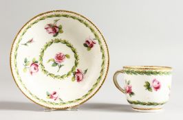 A SEVRES COFFEE CUP AND SAUCER painted with roses between husk borders, gilder's mark for