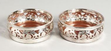 A PAIR OF SILVER PLATED CIRCULAR PIERCED WINE COASTERS.