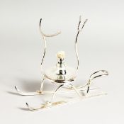 A SILVER PLATED BRANDY WARMER on skis.