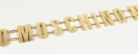A MOSCHINO TRIPLE NAME GILT BELT. 26ins long.