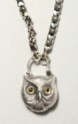A SILVER OWL PADLOCK PENDANT on a chain.