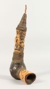 A TRIBAL CARVED AND STAINED BONE FIGURAL PIPE. 13.5ins long.