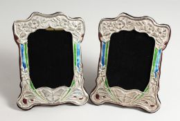 A PAIR OF SILVER AND BLUE ENAMEL BUTTERFLY PHOTOGRAPH FRAMES. 8ins x 5ins.
