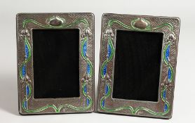 A PAIR OF SILVER AND BLUE ENAMEL ART NOUVEAU DESIGN PHOTOGRAPH FRAMES. 8ins x 5ins.