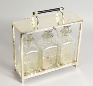 A CHRISTOPHER DRESSER STYLE SILVER PLATED TANTALUS, with blue art glass decanters. 11ins wide.