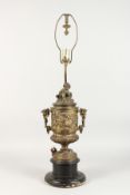 A 19TH CENTURY CUPID TWO-HANDLED URN LAMP on a circular wooden base. 22ins high.
