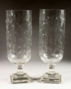A PAIR OF LARGE CUT GLASS STORM LAMPS on square bases.
