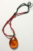 AN AMBER SCORPION PENDANT on a chain.