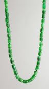 A SUPERB LONG STRING OF CAVED JADE BEADS with gold and diamond clasp.