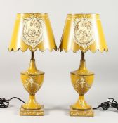 A PAIR OF YELLOW TOLEWARE LAMPS AND SHADES.