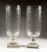 A PAIR OF LARGE CUT GLASS STORM LAMPS on square bases.