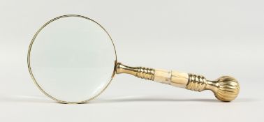 A MAGNIFYING GLASS WITH MOTHER-OF-PEARL AND GILT HANDLE.