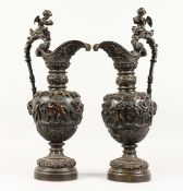 A SUPERB PAIR OF LARGE BRONZE ITALIAN CLASSICAL EWERS, with a band of cupids, rams masks and