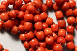 A LONG STRING OF CORAL BEADS.