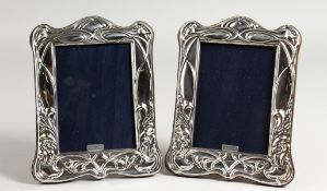 A PAIR OF SILVER ART NOUVEAU DESIGN PHOTOGRAPH FRAMES. 8ins x 6.25ins.