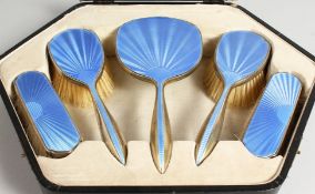 A GUILLOCHE ENAMEL AND SILVER FIVE-PIECE DRESSING TABLE SET, in a fitted case (lacking comb).
