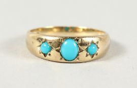 A 9CT YELLOW GOLD THREE-STONE TURQUOISE RING.