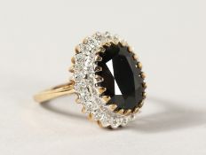 A 9CT GOLD OVAL BLUE STONE AND DIAMOND RING.