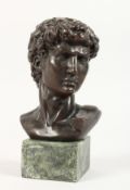 A BRONZE BUST OF A CENTURION on a marble base. 5ins high.