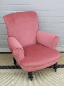 A good blush pink velvet upholstered armchair, raised over short turned legs.